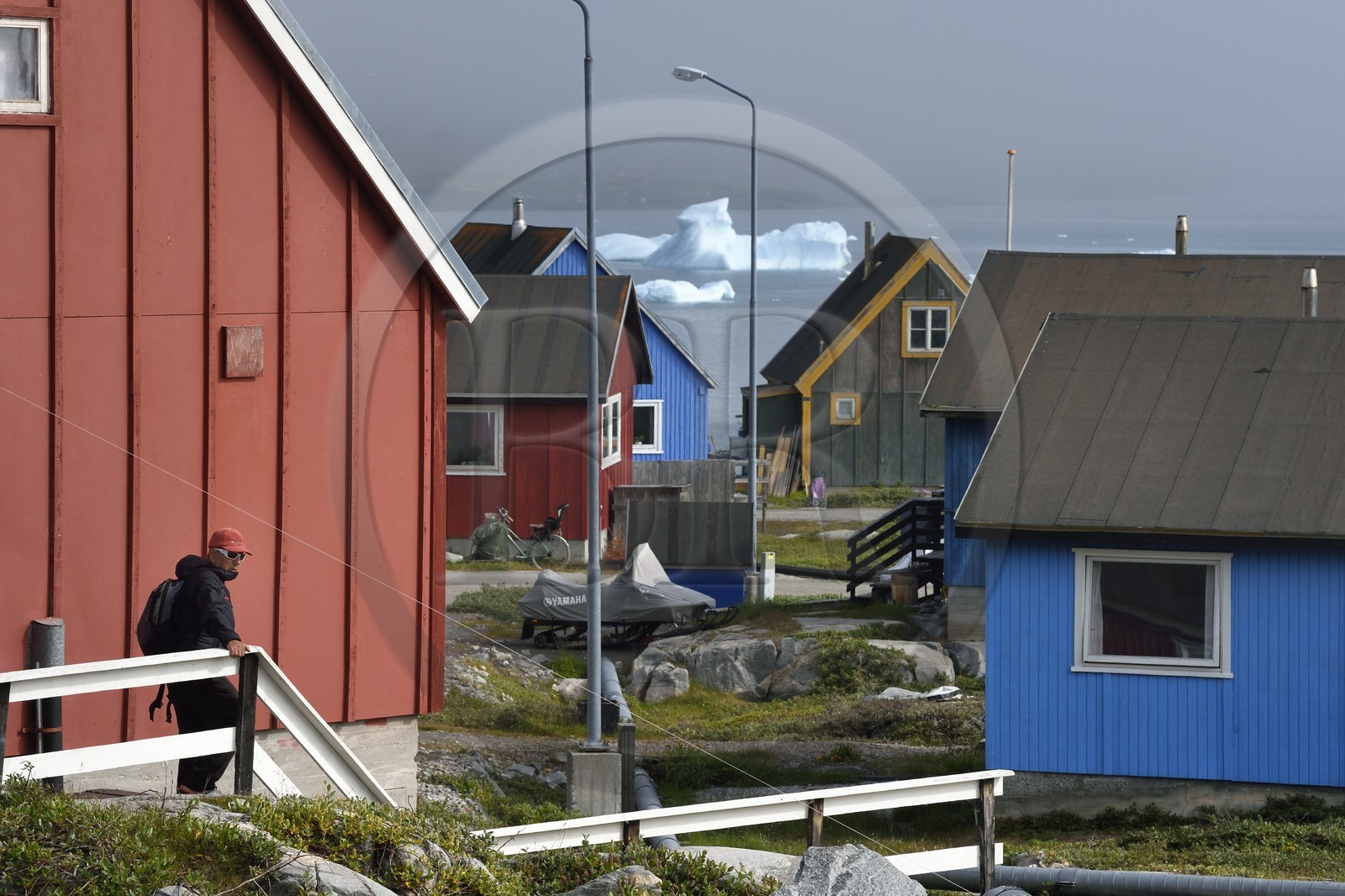 Groenland, cote ouest, Ile de Disko, maisons du village de Qeqertarsuaq et icebergs en arrière plan