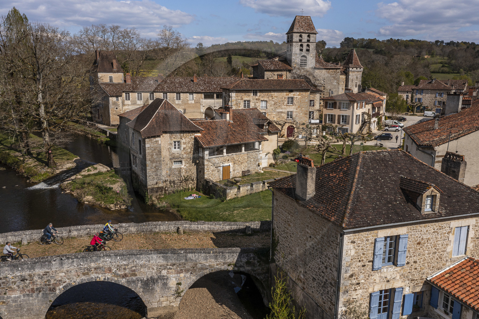 France, Dordogne (24), Périgord Vert, Saint-Jean-de-Côle, labellisé Les Plus Beaux Villages de France, cyclistes faisant la véloroute la Flow Vélo franchissant le pont médiéval du XIIème siècle, le clocher de l'église Saint-Jean-Baptiste (vue aérienne)