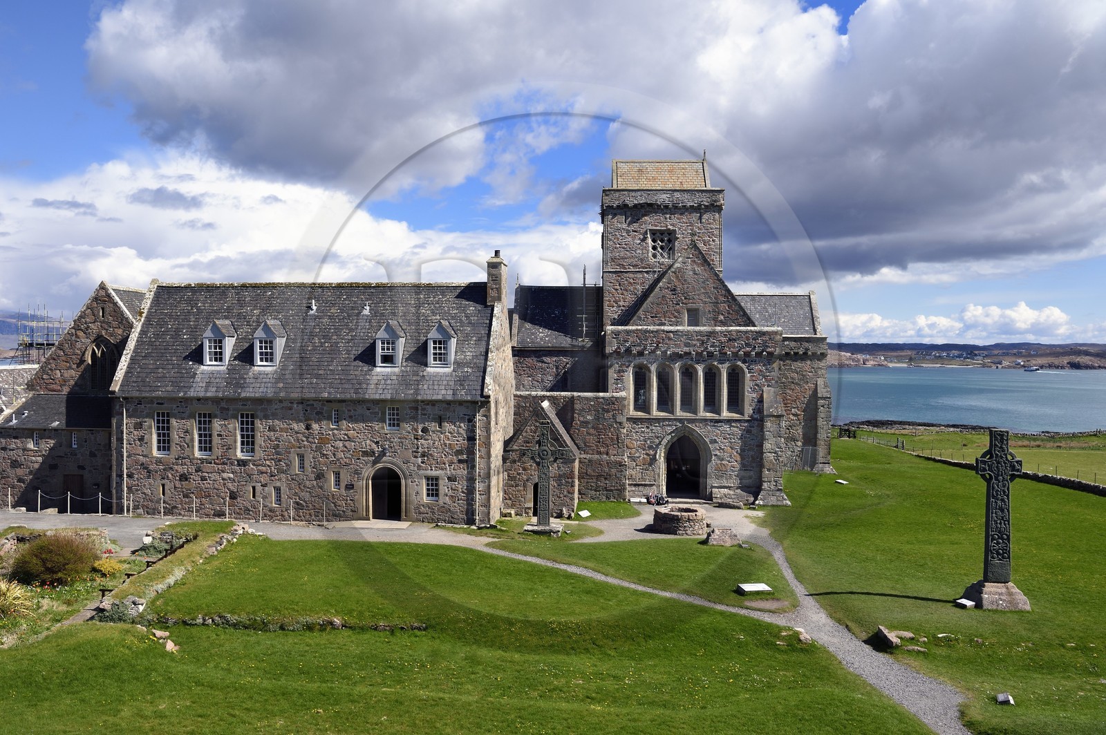 United Kingdom, Scotland, Highland, Inner Hebrides, Isle of Iona facing the Isle of Mull, Iona abbey founded by Saint Columba in the 6th century and St. Martin's Cross on the right