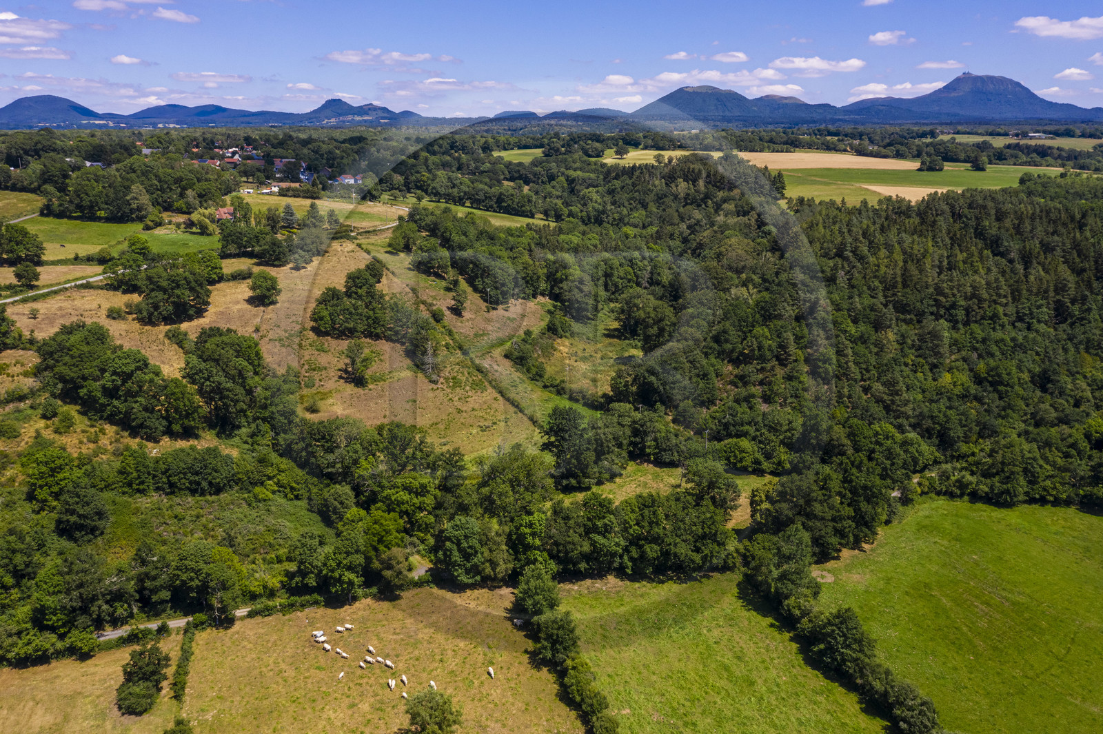France, Puy-de-Dôme (63), la butte basaltique de Saint-Pierre-Le-Chastel surplombant la vallée de la Sioule, la Chaîne des Puys classée Patrimoine Mondial de l’UNESCO, avec le Puy de Côme à gauche, le Grand Suchet et le volcan Puy de Dôme à droite (vue aérienne)