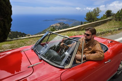 France, Alpes-Maritimes, collection convertible Alfa Romeo Giulietta on a road overlooking the hilltop village of Eze