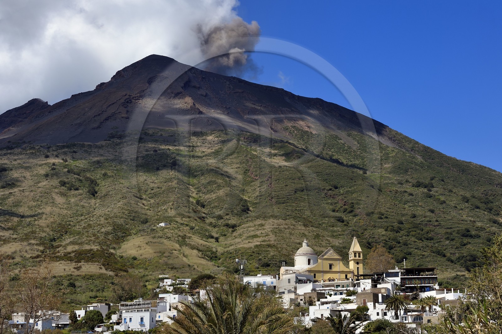 Italie, Sicile, iles Eoliennes, classées Patrimoine Mondial de l'UNESCO, ile de Stromboli, une des multiples et régiulières éruptions du volcan Stromboli qui culmine à 924m, Chiesa di San Vincenzo ( église Saint Vincent) dans le village de Stromboli au premier plan