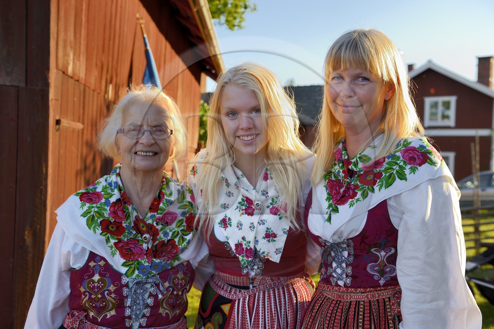 Suède, comté de Dalécarlie, région de Leksand, célébrations du solstice d'été dans le petit hameau de Hjulbäck, trois femmes en costumes traditionnels, grand-mère, mère et fille