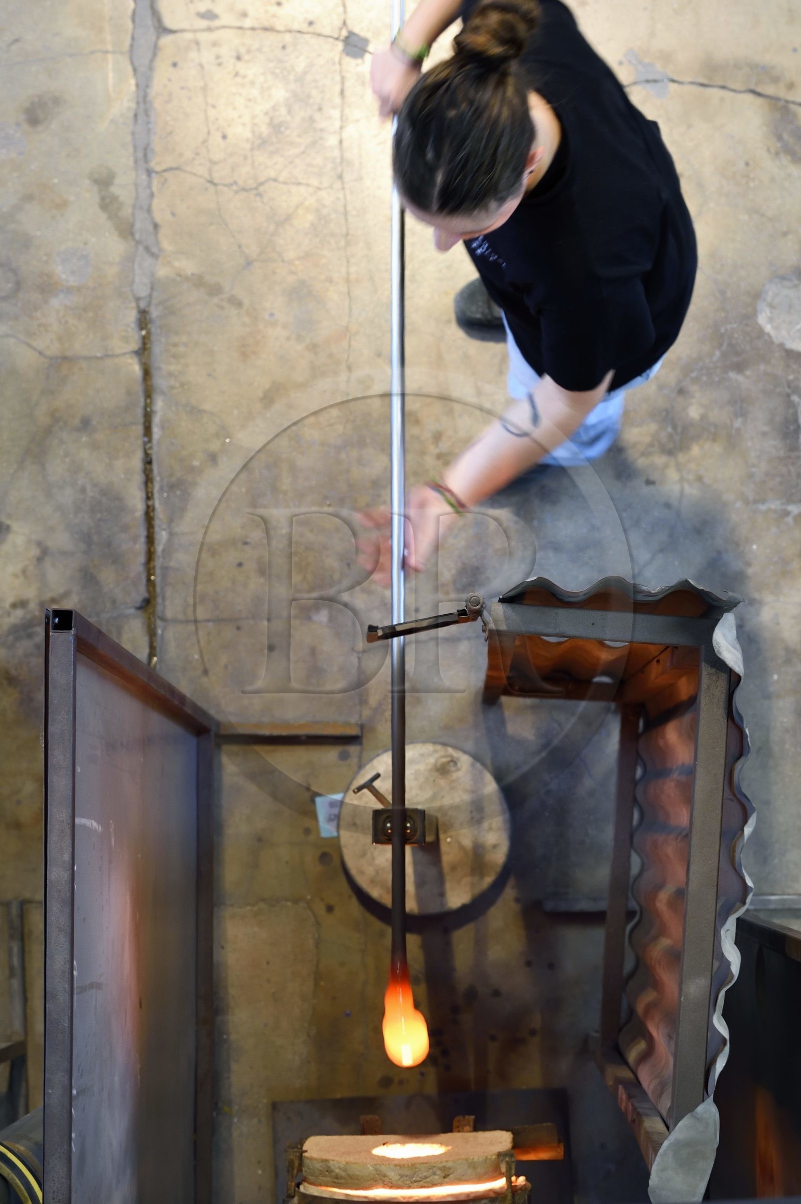France, Moselle (57), Meisenthal, Centre international d’Art verrier (CIAV), l'atelier de soufflage, fabrication artisanale d'une boule de Noël, le souffleur recueille dans le four une masse de verre en fusion avec sa canne de verrier