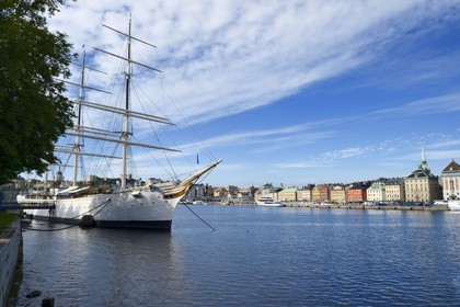 Suède, Stockholm, le voilier STF Vandrarhem af Chapman reconverti en auberge de jeunesse sur l'île de Skeppsholmen et la vieille ville dans l'île de Gamla stan à droite