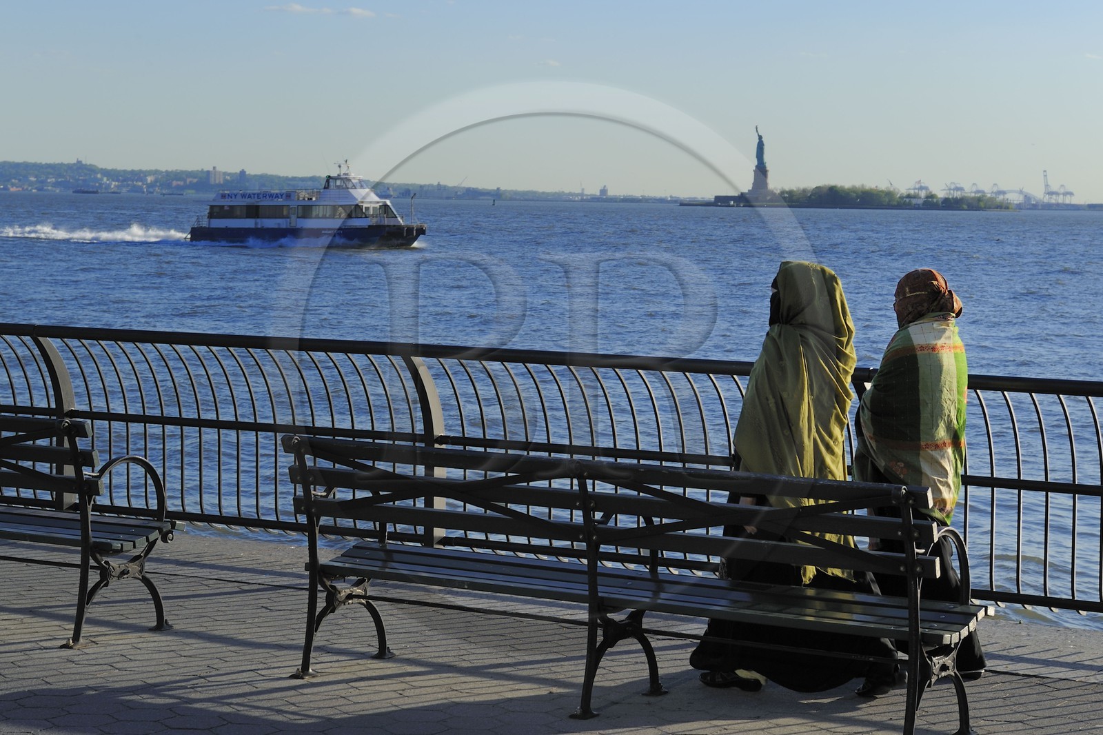 Etats-Unis, New York, Manhattan, pointe Sud, femmes voilée en promenade sur Battery Park et la Statue de la Liberté en arrière plan