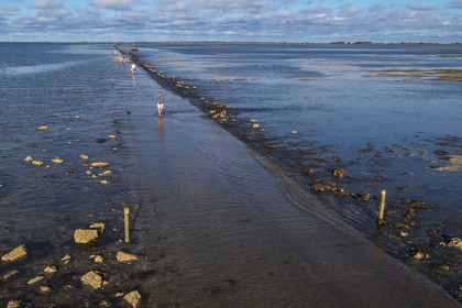 France, Vendée (85), île de Noirmoutier, Barbatre, promeneurs sur le passage du Gois à marée montante, chaussée submersible qui relie l'île au continent à marrée basse (vue aérienne)