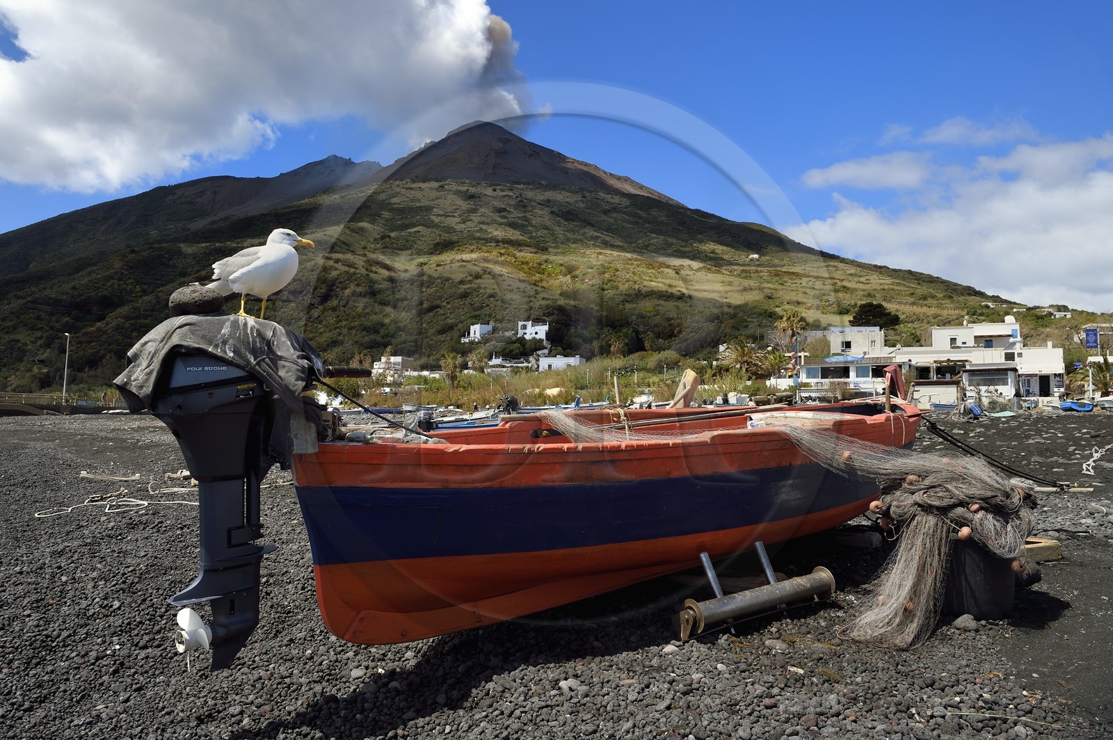 Italie, Sicile, iles Eoliennes, classées Patrimoine Mondial de l'UNESCO, ile de Stromboli, une des multiples et régiulières éruptions du volcan Stromboli qui culmine à 924m, bateau de pêche sur la plage de Scari au premier plan