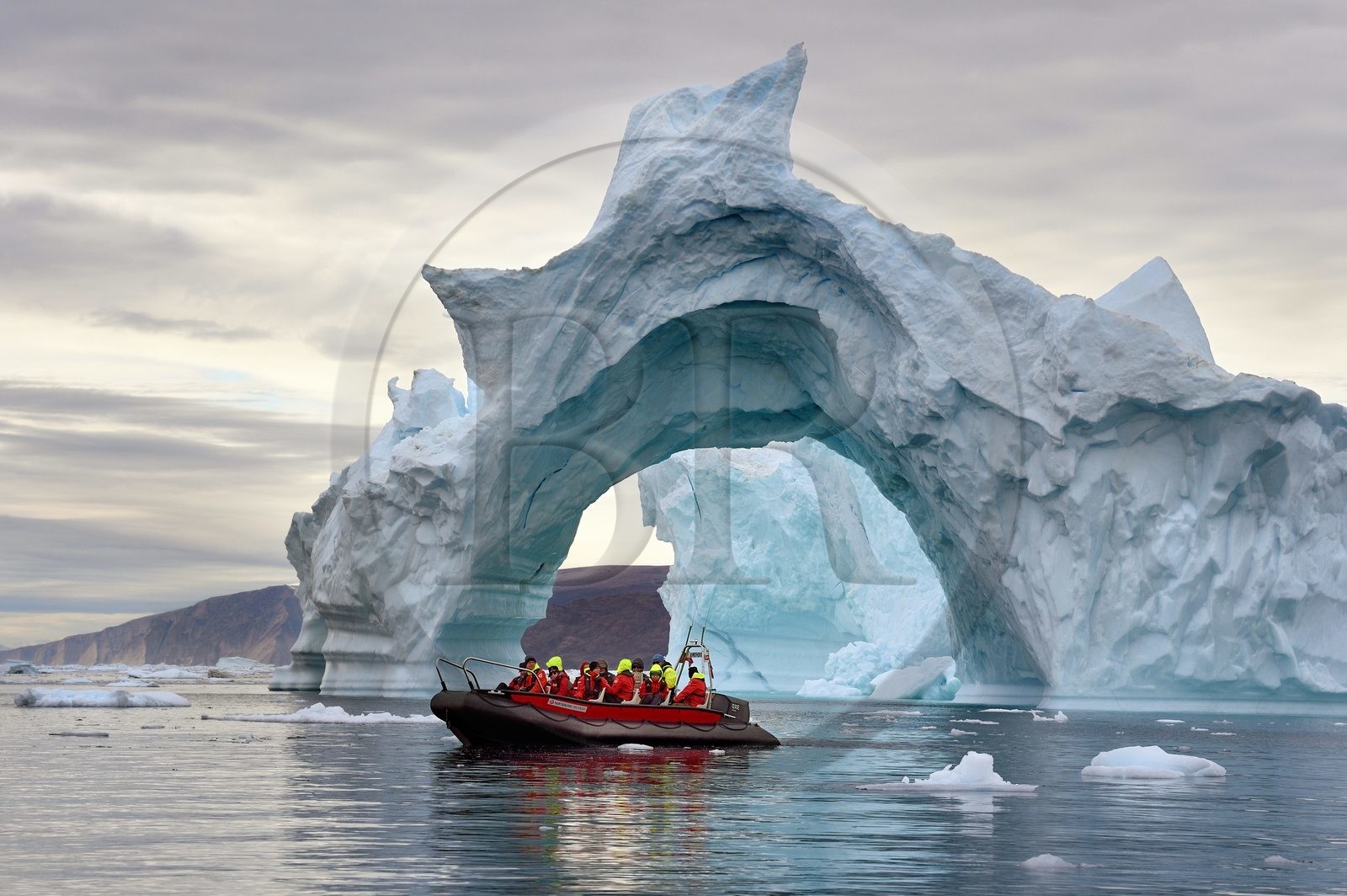 Groenland, cote Nord-Ouest, mer de Baffin, Inglefield Fjord vers Qaanaaq, iceberg formant un arche et un PolarCirkel boat (zodiac) d'exploration du bateau de croisière MS Fram de la compagnie Hurtigruten