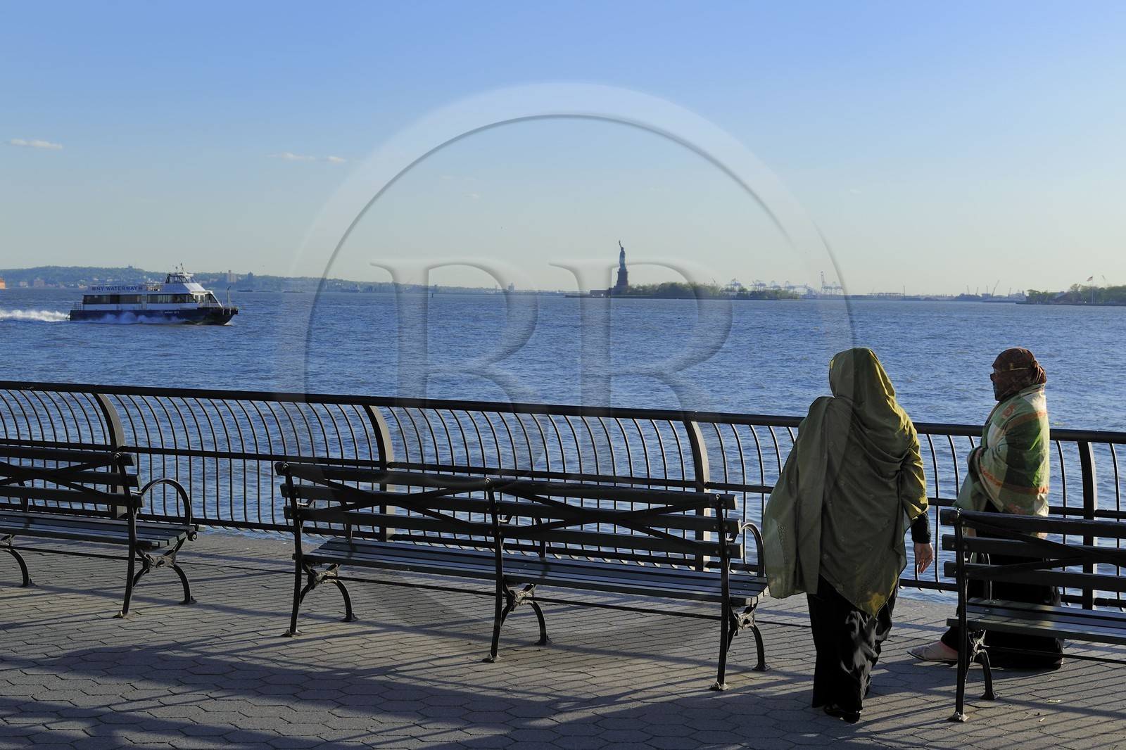 Etats-Unis, New York, Manhattan, pointe Sud, femmes voilée en promenade sur Battery Park et la Statue de la Liberté en arrière plan