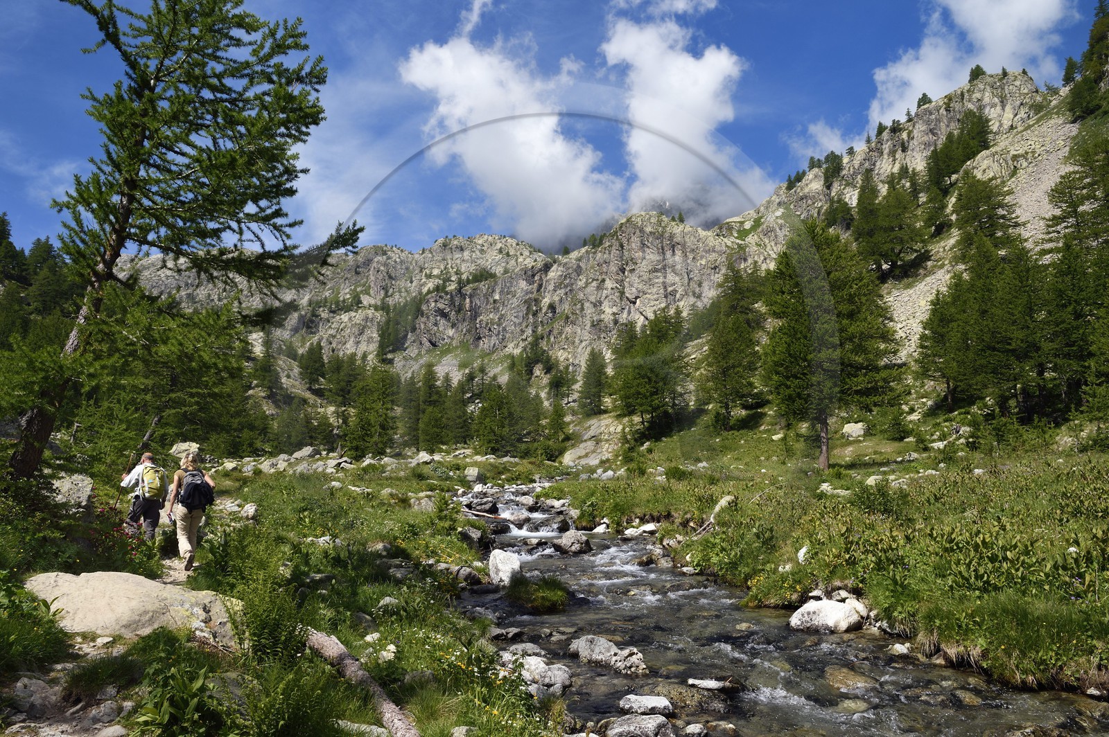 France, Alpes-Maritimes (06), parc national du Mercantour, randonneurs sur le sentier de randonnée de la vallée de la Valmasque et le verrou glaciaire en arrière plan