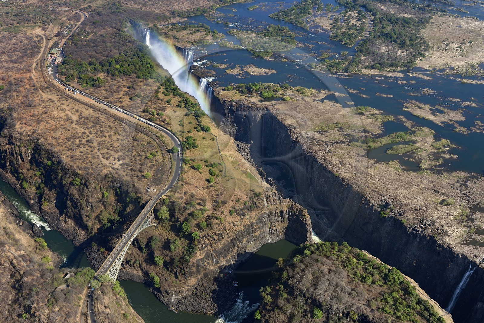 Zimbabwe, province de Matabeleland septentrional, fleuve Zambèze, les Chutes Victoria, classées Patrimoine Mondial de l'UNESCO, pont qui marque la frontière entre le Zimbabwe et la Zambie (vue aérienne)