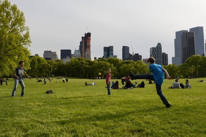 Etats-Unis, New York, Manhattan, Central Park, enfants jouant au football sur le Sheep Meadow, immeubles de Central Park Sud en arrière plan