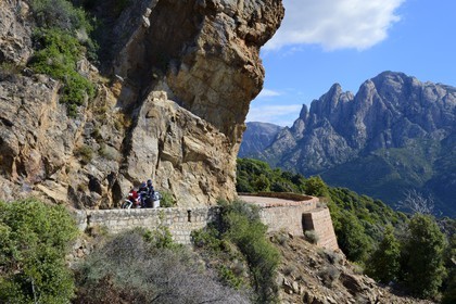 France, Corse du Sud, Golfe de Porto, listed as World Heritage by UNESCO, motorcycle on the D81 road that goes from Calvi to Porto, the Capo d'Orto in the background