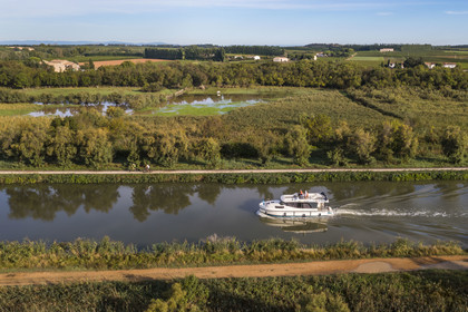 France, Gard (30), la Petite Camargue, navigation d'un bateau de plaisance Le Boat sur le canal du Rhône à Sète entre Gallician et Aigues-Mortes (vue aérienne) France, Gard, the Petite Camargue, navigation of a pleasure boat Le Boat on the Rhone to Sète Canal between Gallician and Aigues-Mortes (aerial view)
