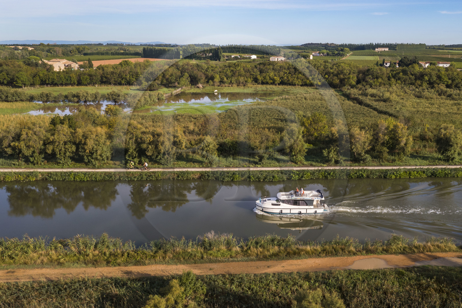 France, Gard (30), la Petite Camargue, navigation d'un bateau de plaisance Le Boat sur le canal du Rhône à Sète entre Gallician et Aigues-Mortes (vue aérienne) France, Gard, the Petite Camargue, navigation of a pleasure boat Le Boat on the Rhone to Sète Canal between Gallician and Aigues-Mortes (aerial view)