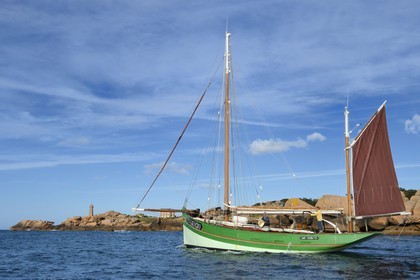 France, Cotes-d'Armor, Cote de Granit Rose (the Pink Granite coast), Perros Guirec, Ploumanach, Pointe de Squewel and Mean Ruz Lighthouse, the traditional sailboat Sant C'hireg (Saint Guirec)