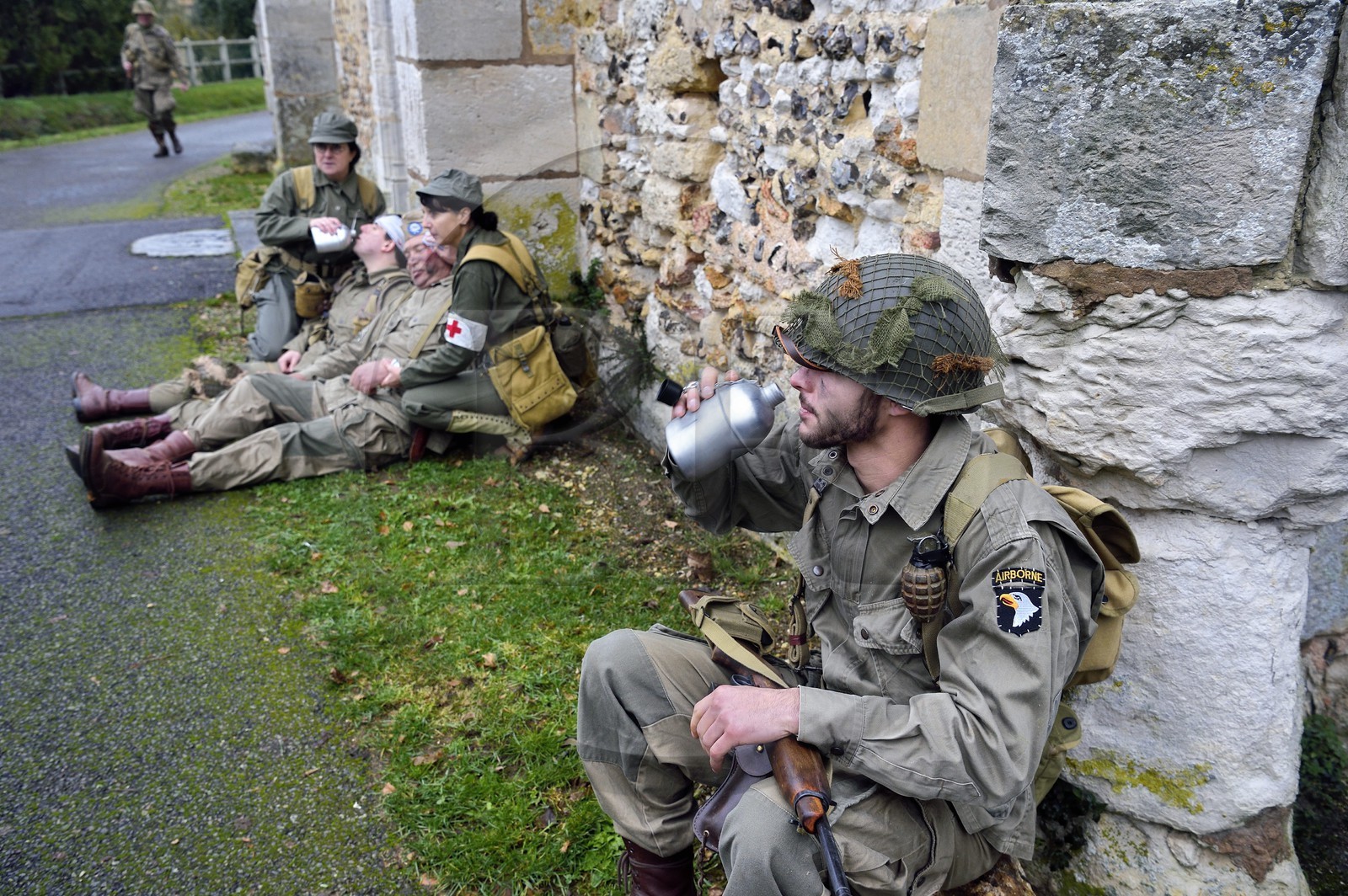 France, Eure, Chambray, Allied Reconstitution Group (US World War 2 and french Maquis historical reconstruction Association), reenactors in uniform of the 101st US Airborne Division resting in front of the church
