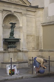 France, Paris (75), dame nettoyant son linge à la fontaine jouxtant le Lycée Charlemagne
