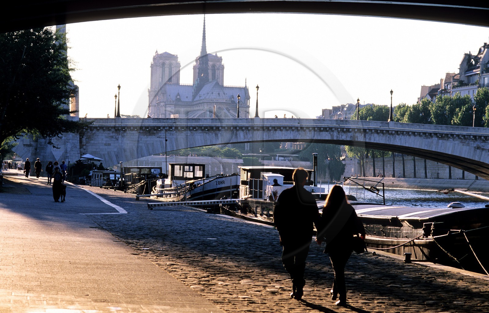France, Paris (75), couple marchant sur le quai et le pont de la Tourelle, Notre-Dame