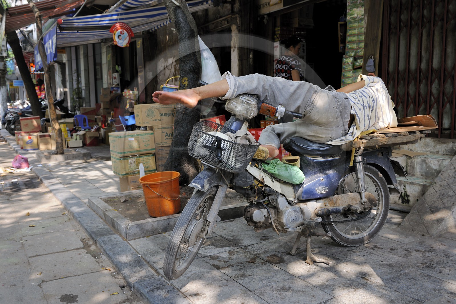 Vietnam, Hanoï, quartier des 36 rues dans la vieille ville, repos d'un livreur sur sa moto