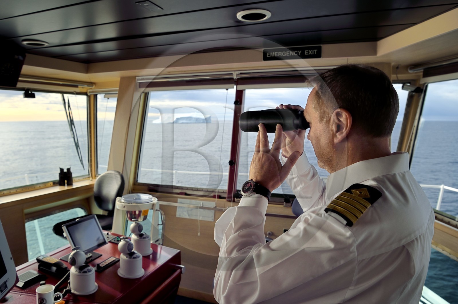 Greenland, North West coast, Baffin Bay, Captain Raymond Martinsen of Hurtigruten's MS Fram cruise ship observes icebergs with binoculars
