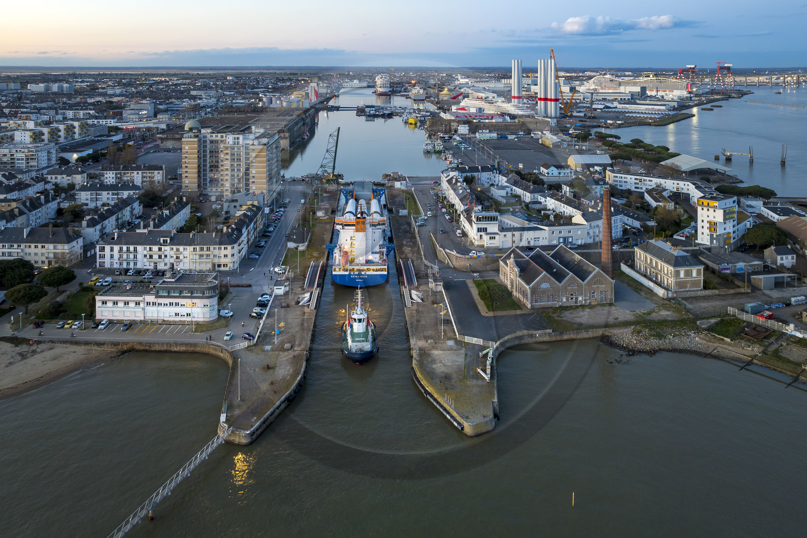 France, Loire-Atlantique (44), Saint-Nazaire, le General Cargo Rotra Mare transporte des sections des mats d'éoliennes et entre dans le bassin à flot du port (en arrière plan) par  l'écluse sud, qui est aussi le lieu de l’Opération Chariot lancée en 1942 par les Britanniques (vue aérienne)