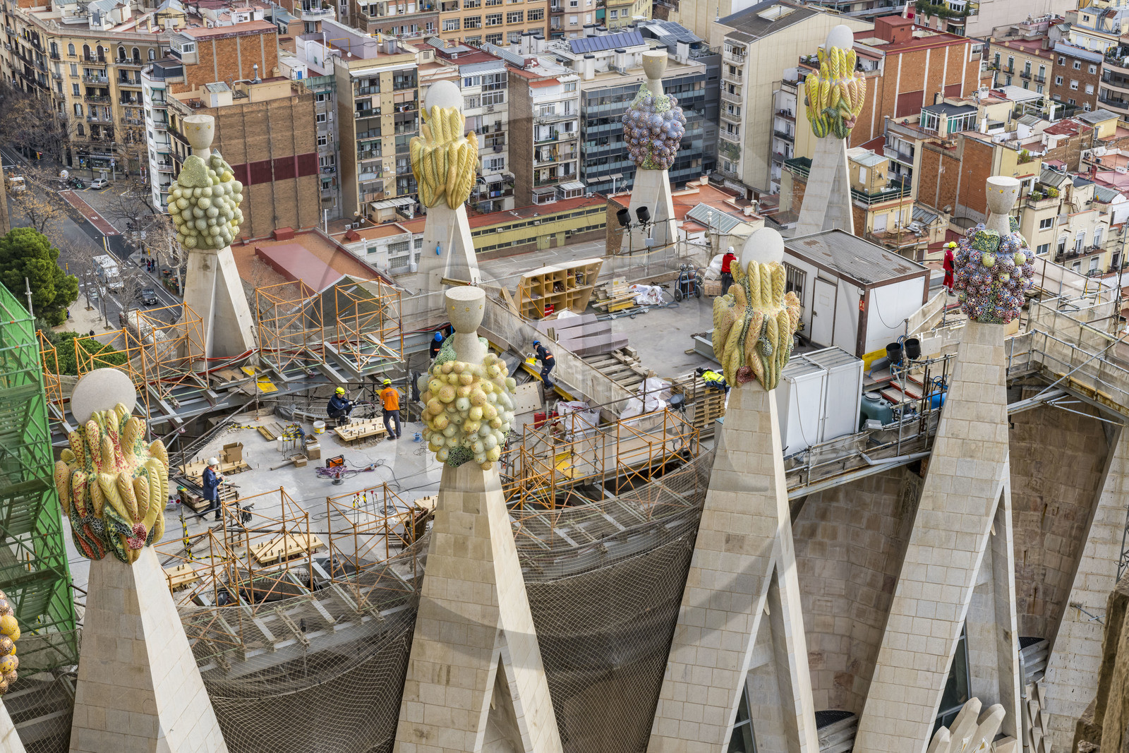 Espagne, Catalogne, Barcelone, quartier de l'Eixample, basilique de la Sagrada Familia de l'architecte du modernisme catalan Antoni Gaudi classée Patrimoine Mondial de l'UNESCO, sommets surmontés de mosaïques en forme de fruits entourant le chantier sur le toit de la nef à l'arrière de la future facade de la Gloire