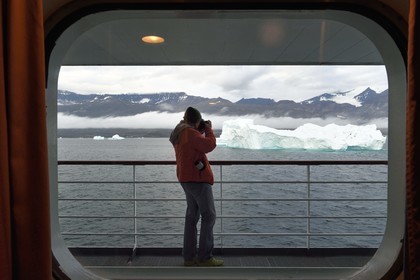 Greenland, west coast, Uummannaq fjord, photographer on board the Hurtigruten's MS Fram cruise ship