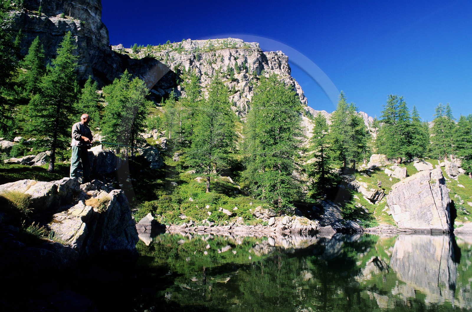 France, Alpes Maritimes, Mercantour National Park, Vallee des Merveilles near Fontanalbe, fisherman at the Green lake