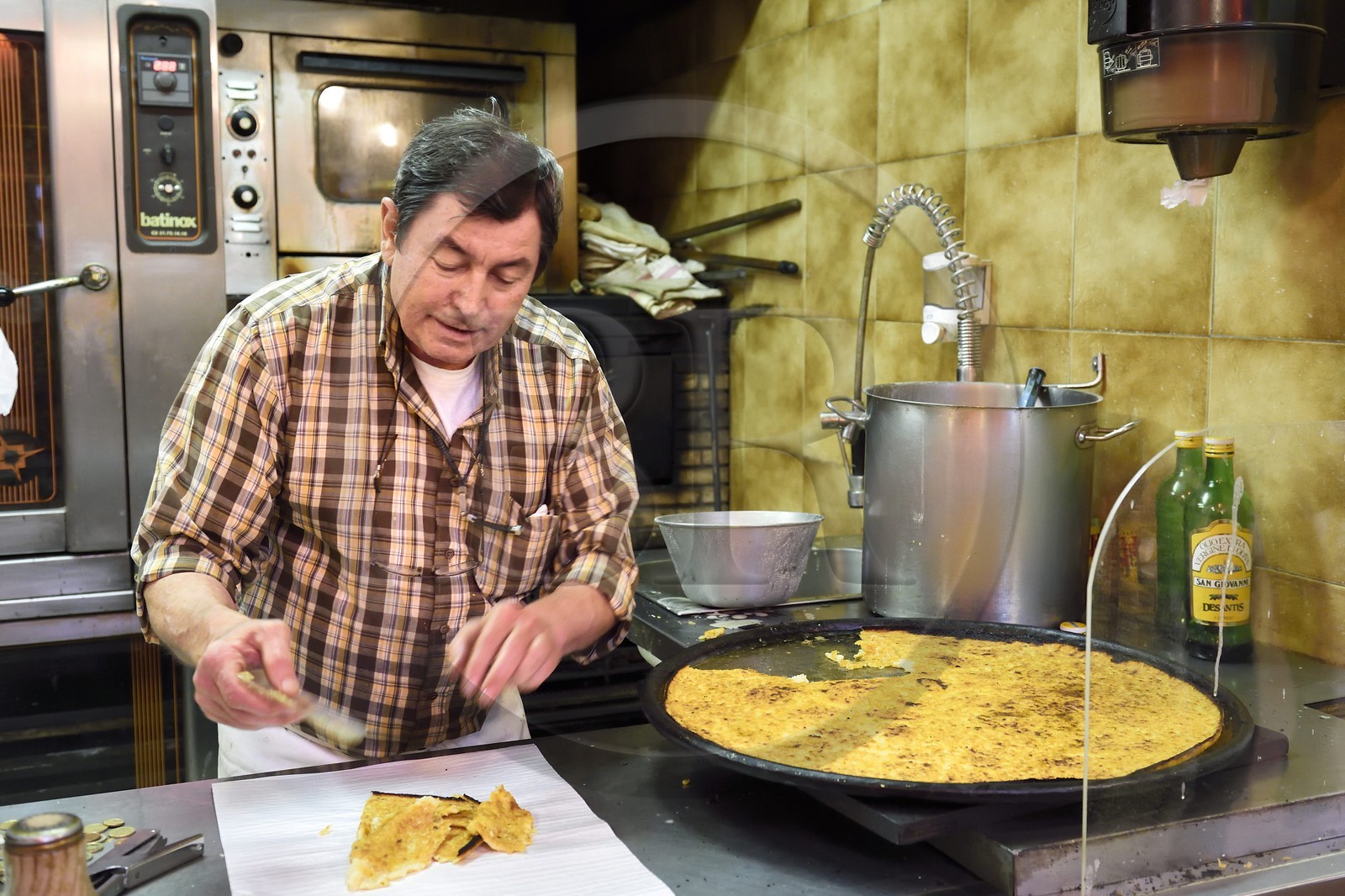 Principauté de Monaco, Monaco, Marché de la Condamine, Roger découpe des parts de socca dans son échoppe