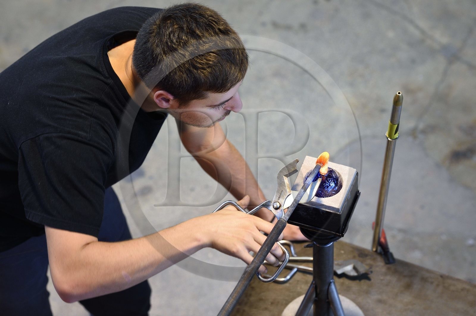 France, Moselle (57), Meisenthal, Centre international d’Art verrier (CIAV), l'atelier de soufflage, fabrication artisanale d'une boule de Noël, pose de la pastille pour la création du crochet en verre