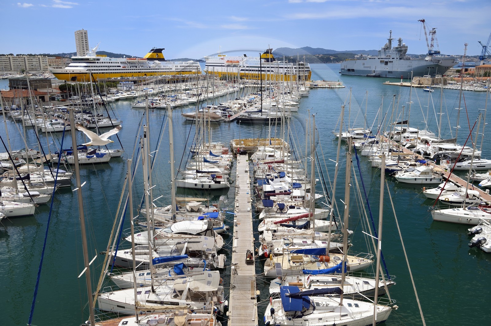 France, Var (83), Toulon, le quai Cronstadt ouvre sur le port civil, en arrière plan à gauche le port marchand et les ferries pour la Corse, en arrière plan à droite la base navale et le Mistral (L9013) porte-hélicoptères amphibie de la Marine nationale française