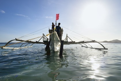 Philippines, Calamian Islands in northern Palawan, Coron Island Natural Biotic Area, Banul Beach, outrigger canoe