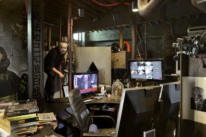 France, Rhône (69), Saint-Romain-au-Mont-d'Or, la Demeure du Chaos, l'œuvre d'art est basé sur la transformation sans fin de la maison du XVIIème siècle de l'artiste plasticien Thierry Ehrmann en une réplique de zone de guerre à l'image du monde présent, portrait de Thierry Ehrmann, aussi président fondateur de Artprice et du Groupe Serveur, sur son bureau