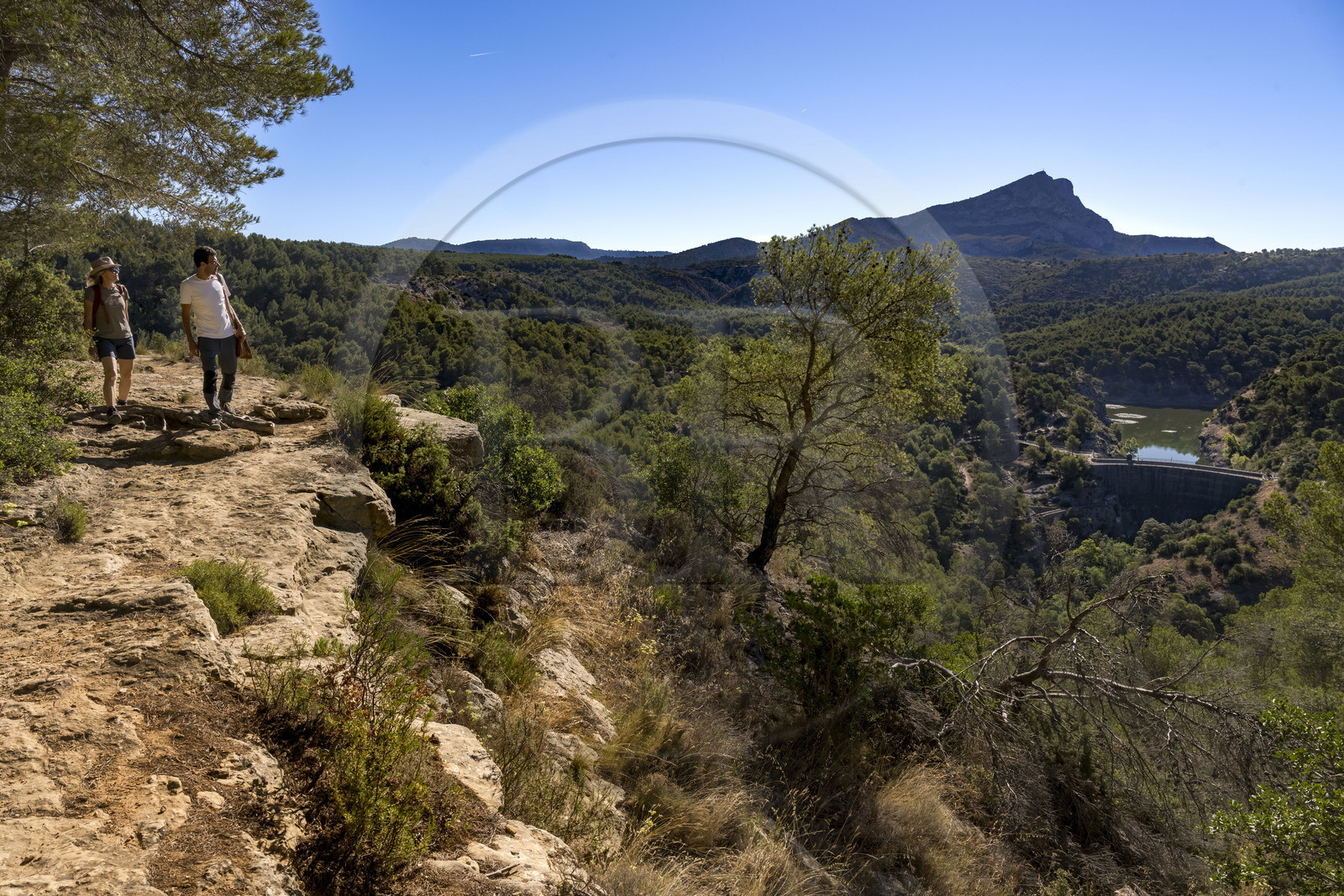 France, Bouches du Rhone, Aix en Provence, hikers on the Bibemus plateau, the Zola dam (Cézanne painted the Bathers series there) and the Sainte Victoire mountain in the background