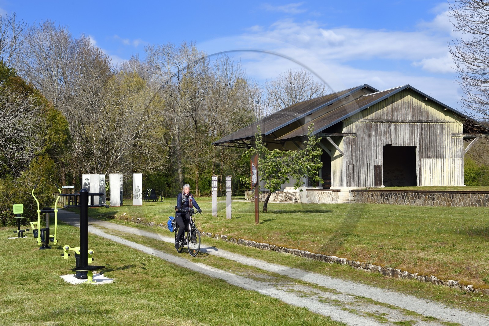 France, Dordogne, Périgord Vert, Saint Jean de Cole labelled Les Plus Beaux Villages de France (The Most Beautiful Villages of France), cyclist on the green lane of the Flow Vélo cycle route which follows the old railway line, hangars of the old station