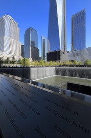 Etats-Unis, New York, Manhattan, 9 11 Memorial dessiné par l'architecte israélien Michael Arad qui consiste en une forêt d'arbres autour de deux étendues d'eau carrées avec deux grands trous en leur centre à l'endroit précis où se tenaient les deux tours et les noms gravés de victimes, le One World Trade Center (1WTC) en arrière plan