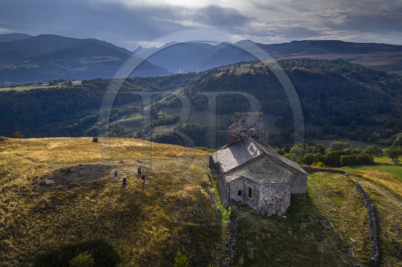 France, Cantal, Parc Naturel Régional des Volcans d'Auvergne (regional nature park of Auvergne volcanoes), Chastel-sur-Murat, 12th century perched on a promontory Saint Antoine (Saint Anthony) Chapel, hickers on the Way of St. James to Santiago de Compostela by Via Arverna (aerial view)