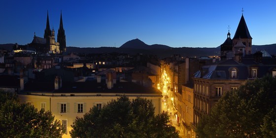 France, Puy-de-Dôme (63), Clermont-Ferrand, la rue du Port entre la cathédrale Notre-Dame de l'Assomption à gauche et la basilique Notre-Dame-du-Port à droite, en arrière plan l'ancien volcan le Puy de Dome