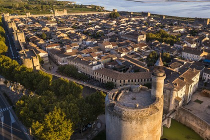 France, Gard, Aigues Mortes, the medieval town surrounded by its ramparts, the Tower of Constance in the foreground and the salt marshes (Salins du Midi) in the background (aerial view)