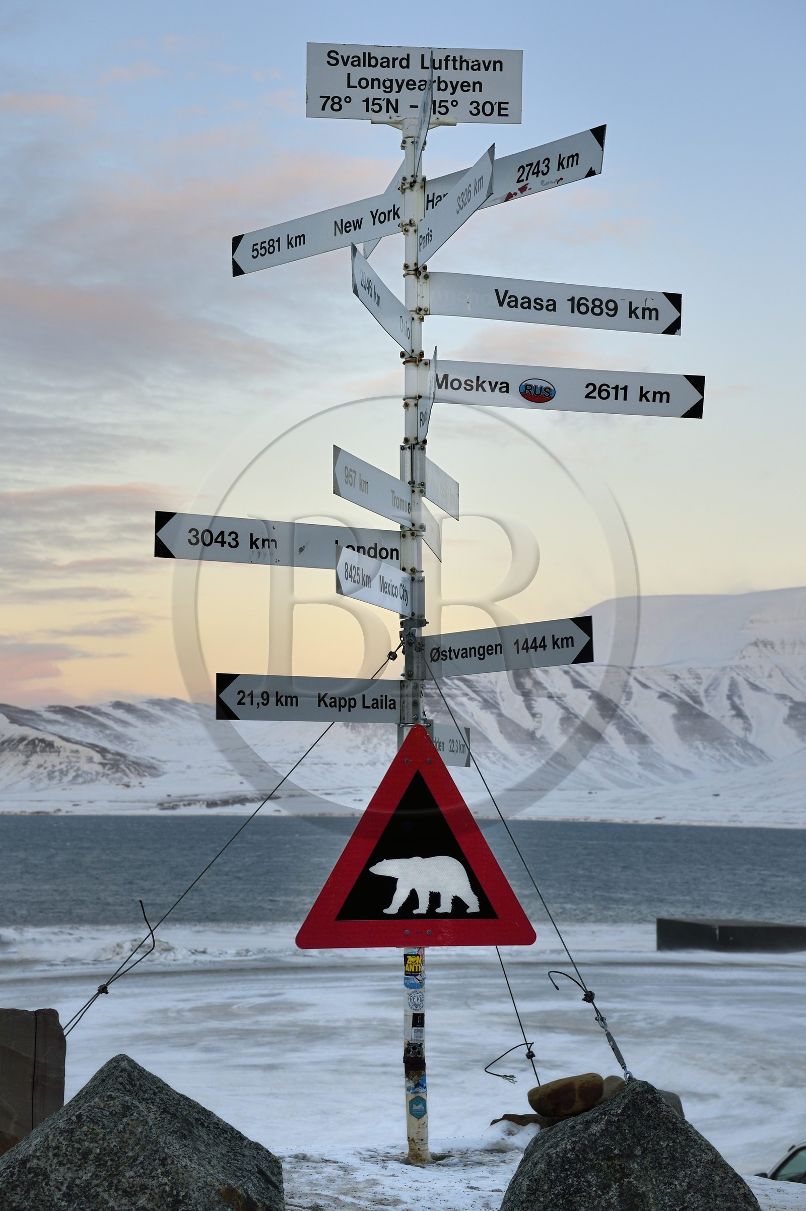 Norvège, Svalbard, Spitzberg, Longyearbyen, panneaux de direction devant l'aéroport de Longyearbyen et panneau de signalisation de danger potentiel de présence d'ours blanc