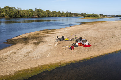 France, Maine-et-Loire (49), vallée de la Loire classée au Patrimoine Mondial par l'UNESCO, randonnée à bicyclette le long des berges de la Loire, campement pour la nuit sur un des bancs de sable formant des îles sur la Loire, une gabarre (bateau traditionnel à fond plat) en arrière plan (vue aérienne)