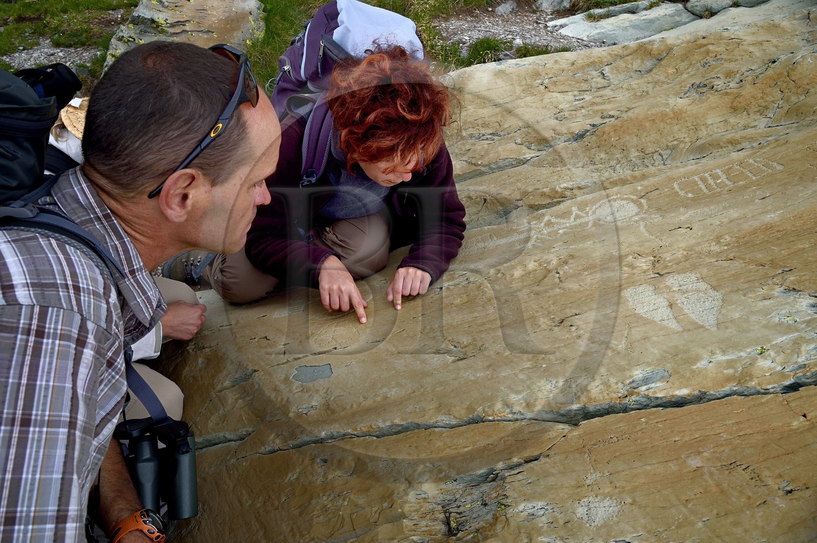 France, Alpes-Maritimes (06), parc national du Mercantour, Vallée des Merveilles parsemée de milliers de gravures rupestres de l'Age de bronze, Pas de l'Arpette, gravure baptisée l'Anthropomorphe aux bras en zigzag, un réticulé de cases qui symboliserait les champs cultivés à droite, deux poignards et de fines incisions linéaires qu'étudie l'archéologue Nicoletta Bianchi