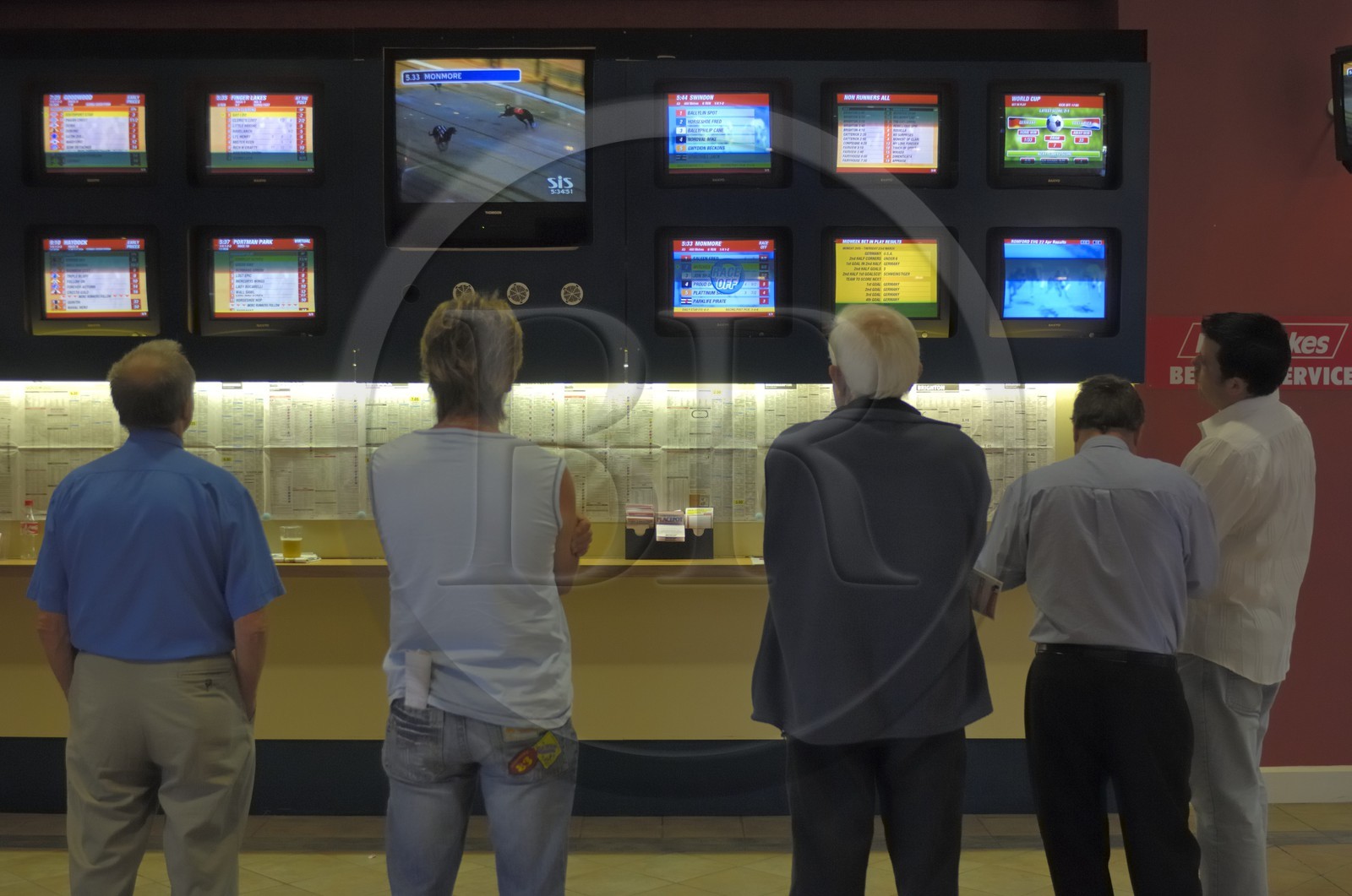 Irlande, Co. Meath, hippodrome de Fairyhouse, parieurs devant les écrans de courses de lévriers