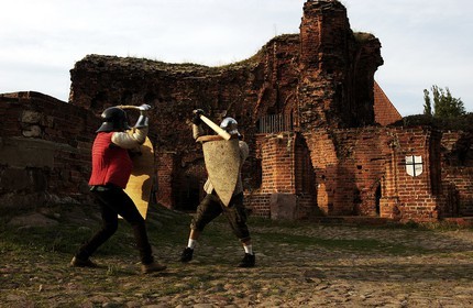 Pologne, Kujavie-Poméranie, ville de Torun, jeunes gens s'entrainant à des simulations de combats devant les ruines du château des chevaliers Teutoniques