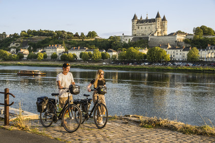 France, Maine-et-Loire (49), vallée de la Loire classée au Patrimoine Mondial par l'UNESCO, Saumur, randonnée à bicyclette sur les berges de la Loire, le chateau et l'église Saint-Pierre sur les bords de Loire