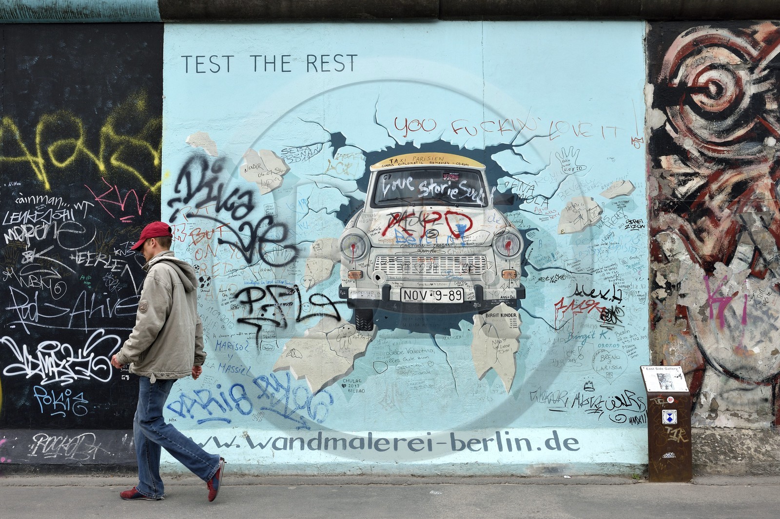 Germany, Berlin, Friedrichshain-Kreuzberg, East Side Gallery, The Wall, work by Birgit Kinder dating from the 1990's, renovated in 2009, representing a Trabant arriving in East Berlin, entitled Test the Best