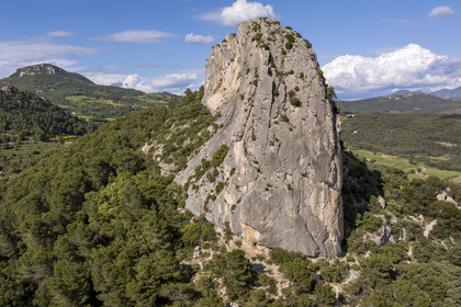 France, Vaucluse, Dentelles de Montmirail mountains, Lafare, limestone peak in the shape of a sugar loaf on one of the foothills of the Dentelles Sarrasines at the Col du Cayron and overlooking the Saint-Christophe waterfall on La Salette, the Saint-Christophe chapel on the right and the summit of the Saint Amand ridge in the background left (aerial view)