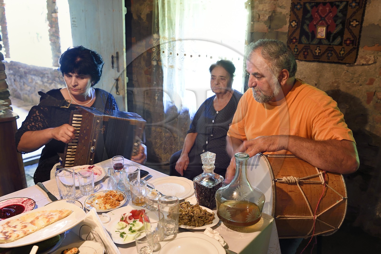 Géorgie, Kakheti, Akhmeta, repas traditionnel de fête dans une famille de Touchétie, chants accompagnés de l'accordéon et du tambour